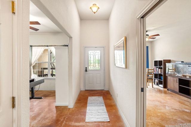 entrance foyer featuring baseboards, ceiling fan, and concrete flooring