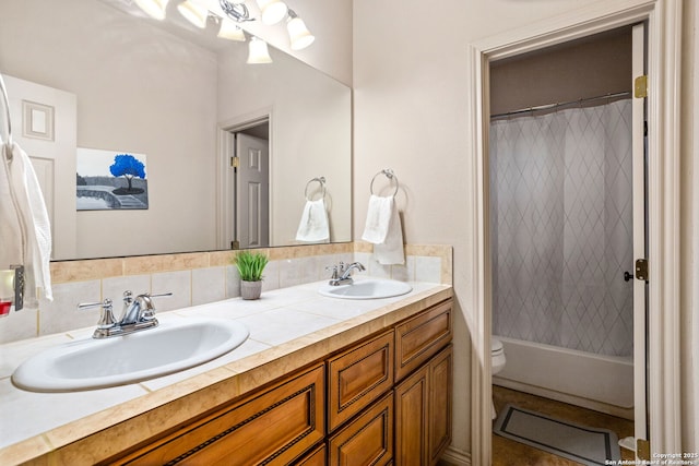 full bath featuring double vanity, a sink, shower / bath combination with curtain, and toilet