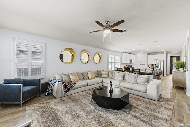 living area with recessed lighting, ceiling fan, and light wood-style floors