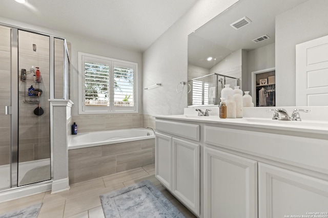 bathroom with double vanity, visible vents, a shower stall, a sink, and tile patterned floors