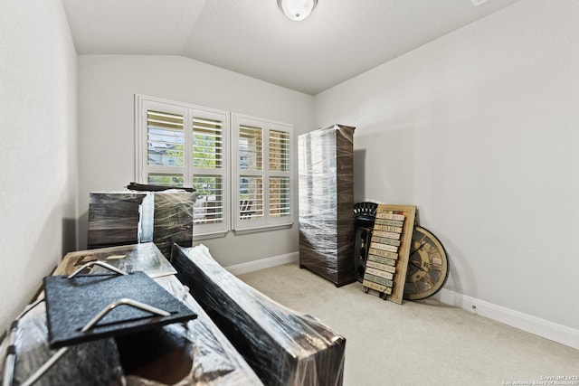 carpeted office featuring baseboards and vaulted ceiling