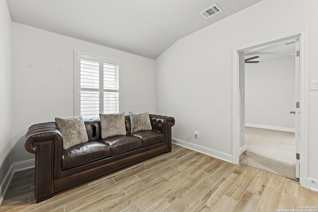 living room with visible vents, baseboards, lofted ceiling, and wood finished floors