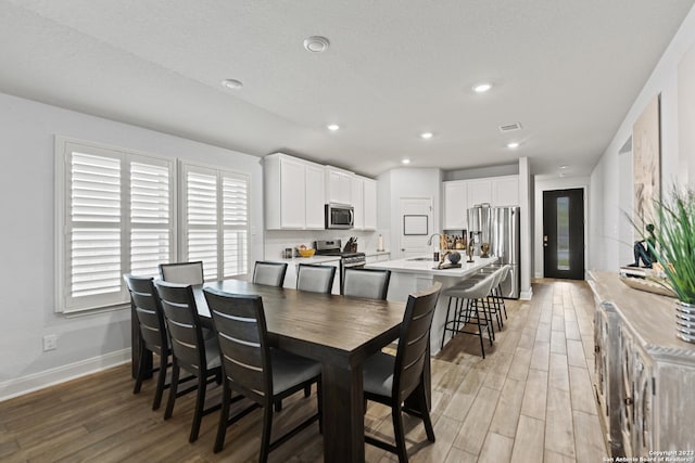 dining space with baseboards, recessed lighting, light wood finished floors, and visible vents
