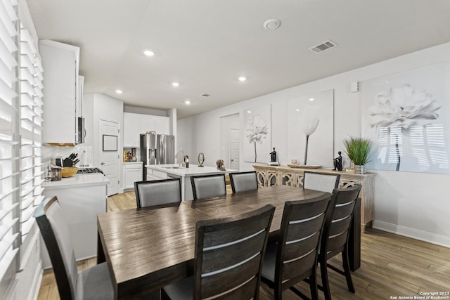 dining room with light wood-style floors, baseboards, recessed lighting, and visible vents