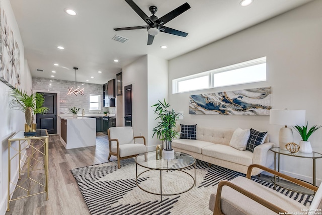 living area with recessed lighting, a ceiling fan, visible vents, and light wood-type flooring