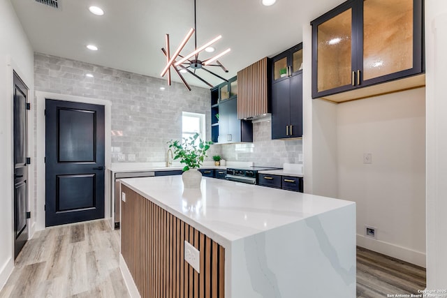kitchen featuring open shelves, light wood-type flooring, tasteful backsplash, a kitchen island, and stainless steel electric stove