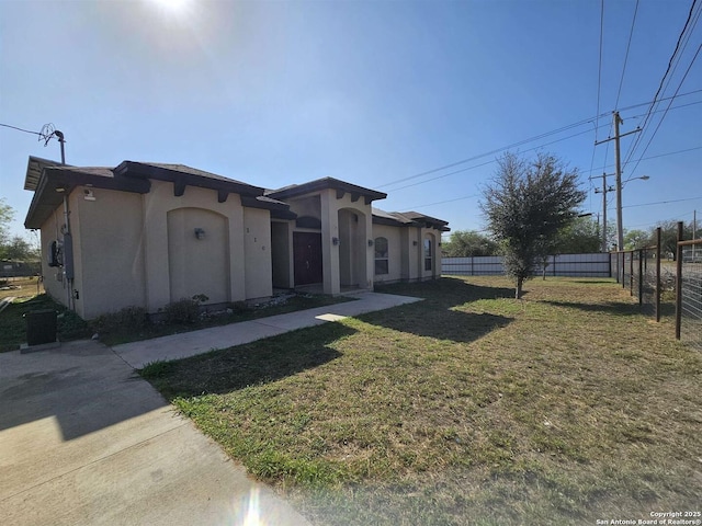 mediterranean / spanish-style home with a front lawn, stucco siding, and fence