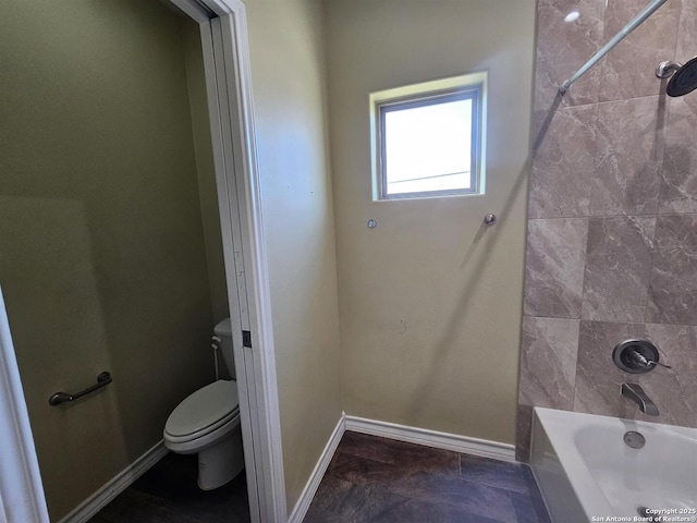 bathroom featuring toilet, baseboards, tub / shower combination, and marble finish floor