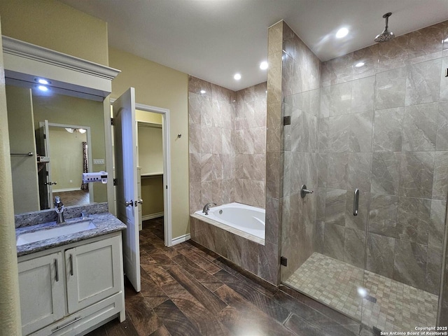 full bath with vanity, marble finish floor, baseboards, a shower stall, and a garden tub