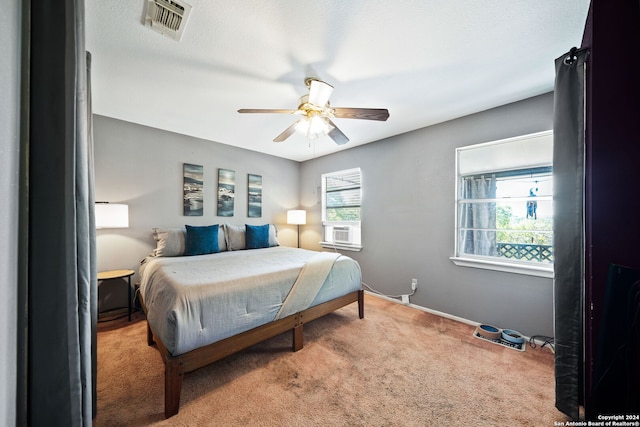 carpeted bedroom featuring baseboards, visible vents, multiple windows, and cooling unit