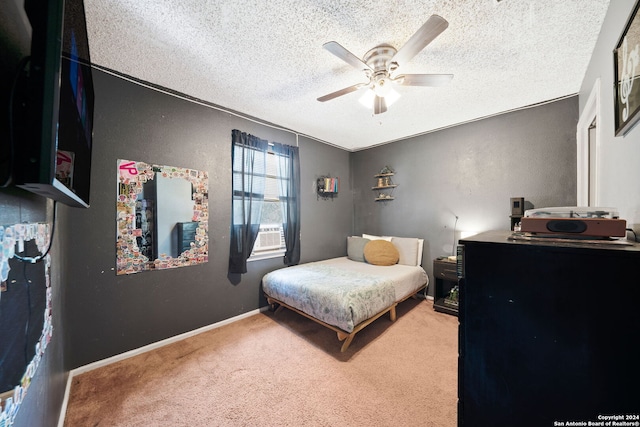 bedroom with carpet flooring, a ceiling fan, and a textured ceiling