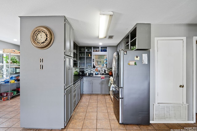 kitchen with open shelves, gray cabinets, freestanding refrigerator, and visible vents