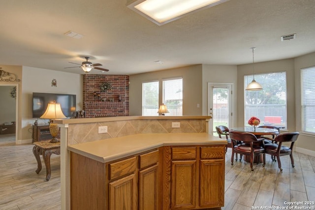 kitchen featuring light countertops, ceiling fan, visible vents, and light wood-type flooring