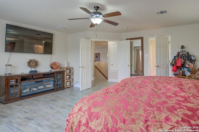 bedroom with visible vents, baseboards, ceiling fan, and wood finished floors