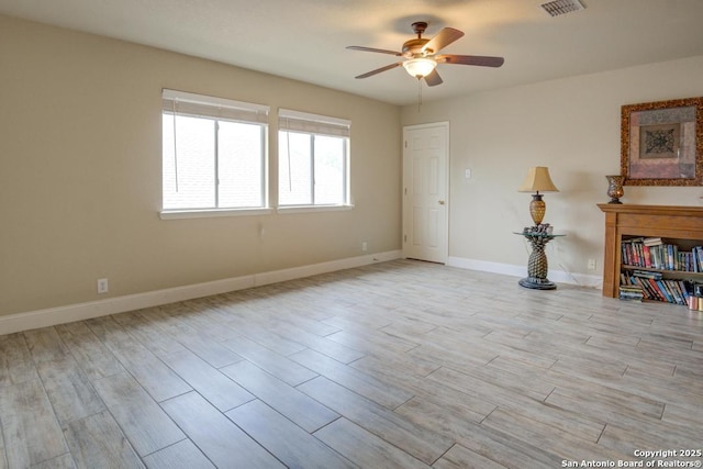 unfurnished room featuring a ceiling fan, baseboards, visible vents, and light wood-style floors
