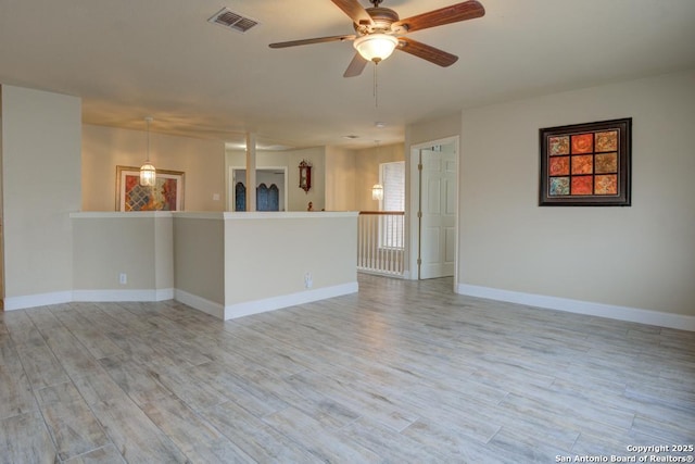 unfurnished room featuring ceiling fan, visible vents, baseboards, and light wood finished floors