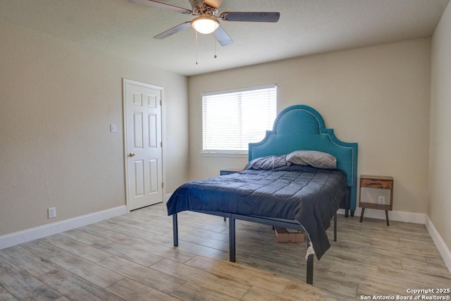 bedroom featuring baseboards, a ceiling fan, and wood finished floors