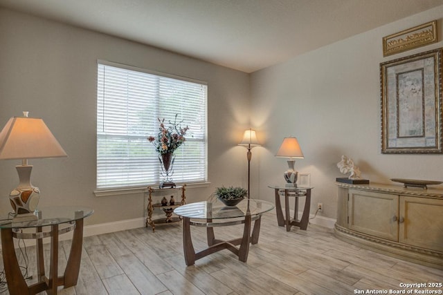living area with light wood-style floors and baseboards