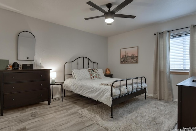 bedroom with baseboards, light wood finished floors, and ceiling fan