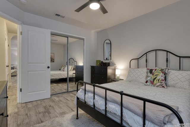 bedroom with a ceiling fan, a closet, light wood finished floors, and visible vents