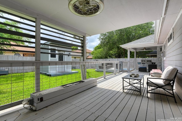wooden terrace with a lawn, an outdoor living space, and a fenced backyard