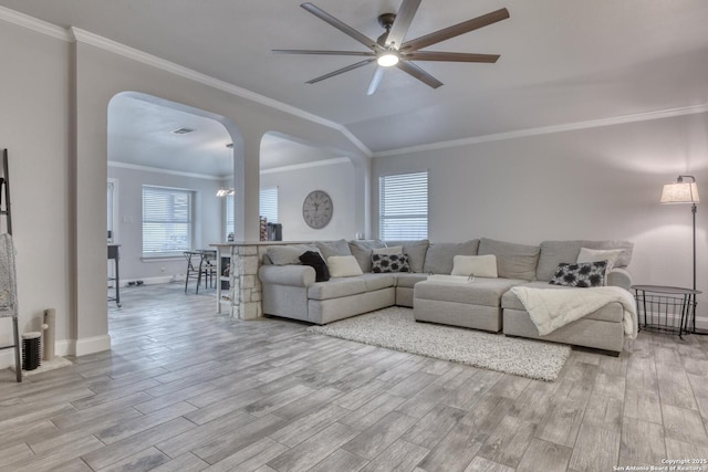 living area featuring visible vents, a ceiling fan, wood finished floors, baseboards, and arched walkways