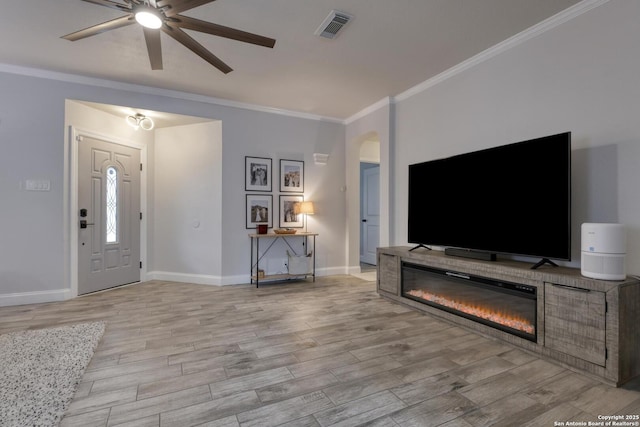 entryway featuring visible vents, a ceiling fan, baseboards, and crown molding