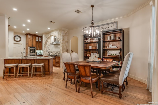 dining space with arched walkways, a chandelier, ornamental molding, and visible vents