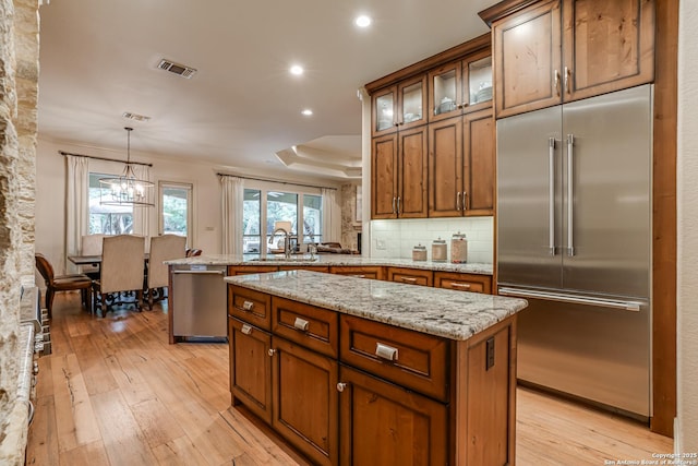 kitchen with visible vents, recessed lighting, light wood-type flooring, brown cabinets, and appliances with stainless steel finishes