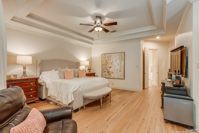 bedroom featuring ornamental molding, baseboards, light wood-type flooring, a raised ceiling, and a ceiling fan