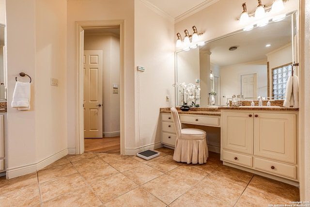 bathroom featuring crown molding, vanity, tile patterned flooring, and baseboards