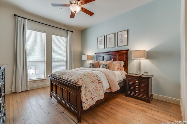 bedroom with baseboards, light wood-style flooring, and ceiling fan