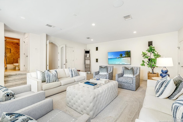 living area with arched walkways, recessed lighting, and visible vents