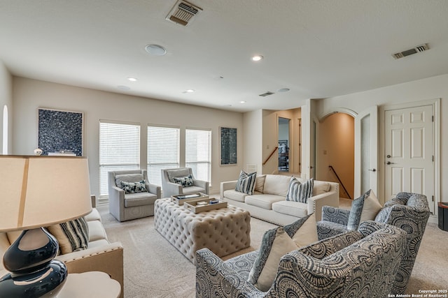 living room with visible vents, recessed lighting, and light carpet