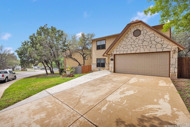 view of front of house featuring fence, a front lawn, stone siding, a garage, and concrete driveway