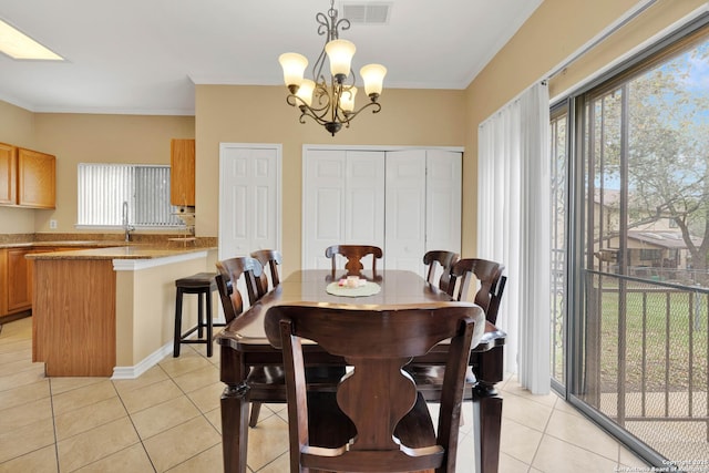 dining space with light tile patterned floors, ornamental molding, a chandelier, and visible vents