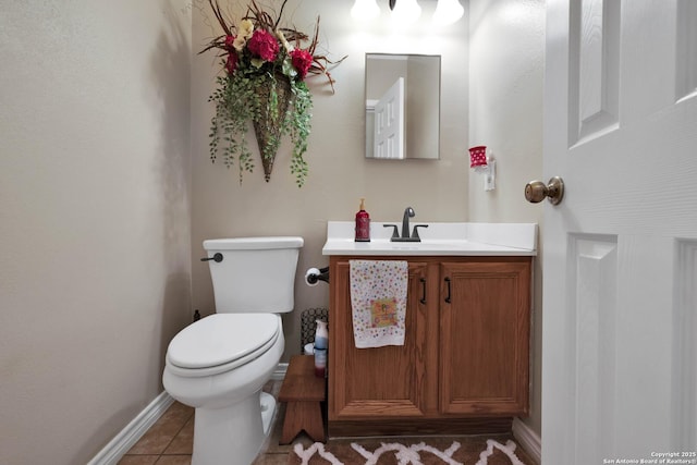 bathroom with vanity, tile patterned floors, baseboards, and toilet