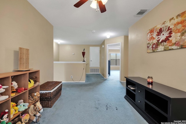 living area with ceiling fan, an upstairs landing, carpet, and visible vents