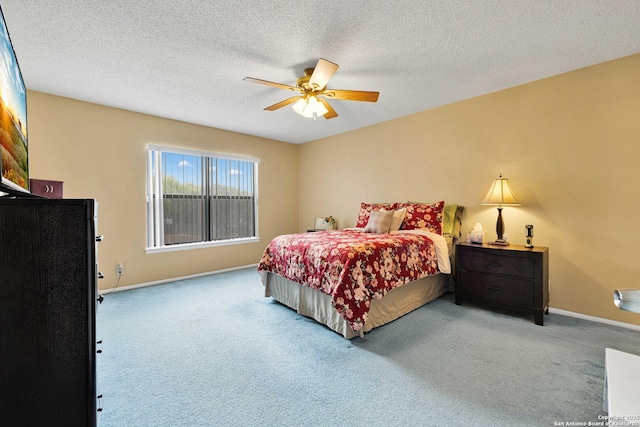 carpeted bedroom with a ceiling fan, baseboards, and a textured ceiling