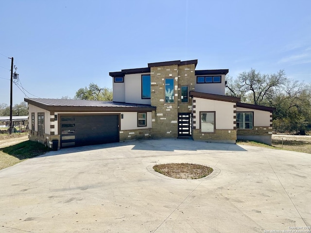 contemporary home with a garage, curved driveway, and stucco siding