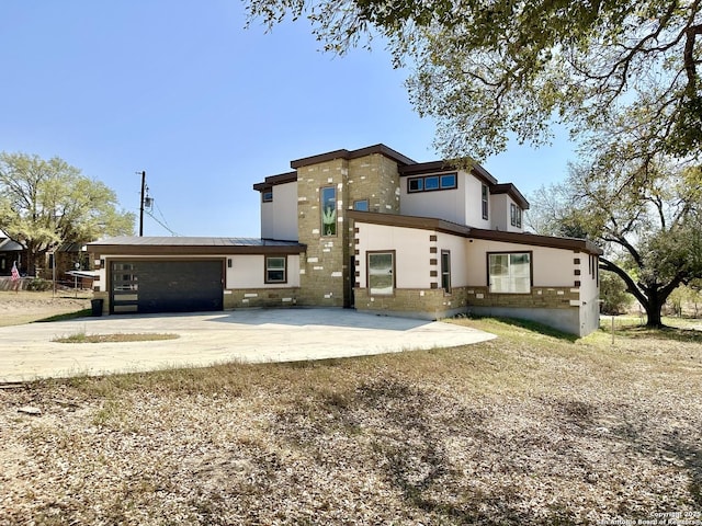 view of front of home with a garage, stucco siding, and driveway