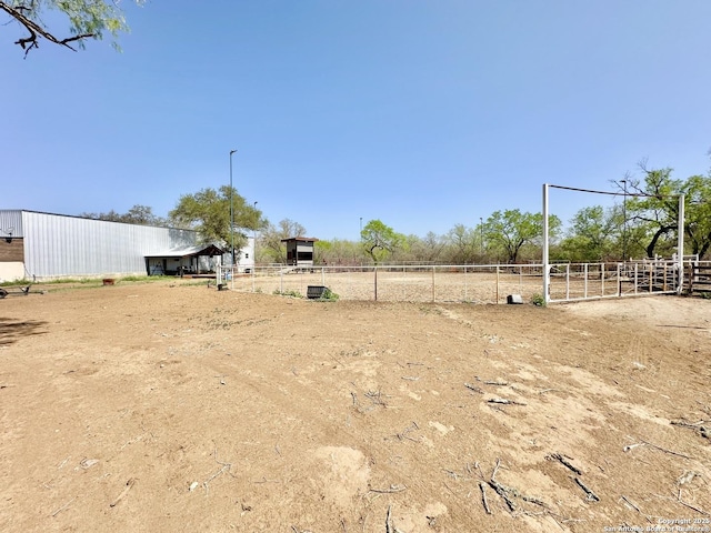 view of yard with fence and a rural view