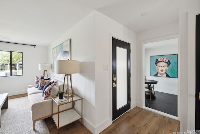 foyer featuring baseboards and wood finished floors