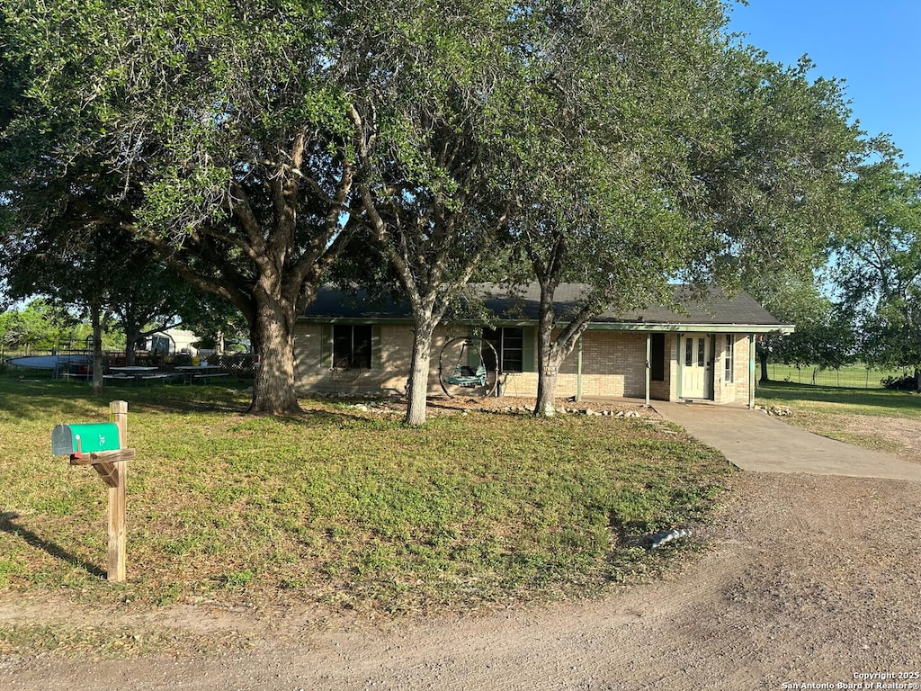 view of front of house with driveway and a front lawn
