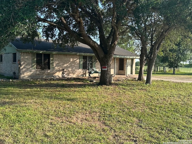ranch-style home featuring brick siding, a front lawn, and a porch