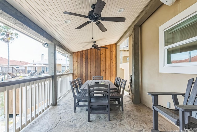 sunroom with a ceiling fan and outdoor dining space