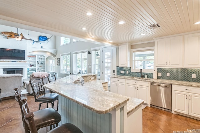 kitchen featuring a breakfast bar, a wealth of natural light, a sink, and dishwasher