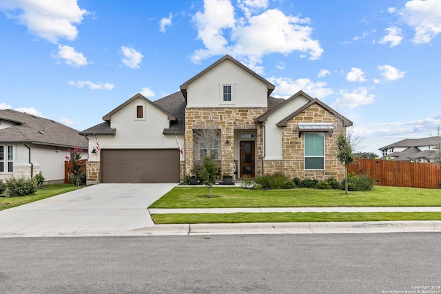 view of front of house featuring fence, stone siding, stucco siding, a front yard, and concrete driveway
