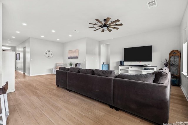 living room with visible vents, a ceiling fan, and light wood-style flooring