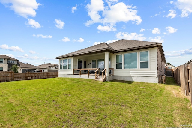 back of property featuring a lawn, a fenced backyard, and roof with shingles